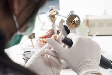 Dental technician working with articulator