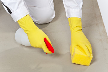 worker clean cement substrate with sponge