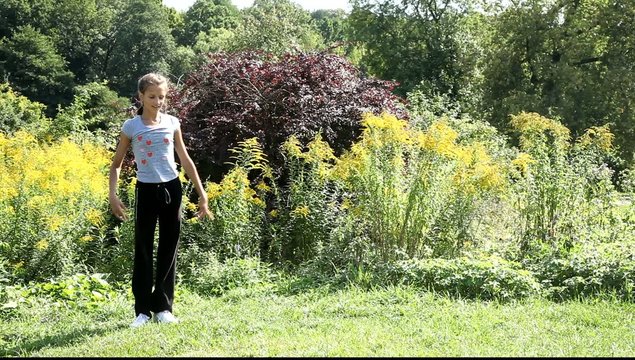 Девушка проводит гимнастическую тренировку на природе