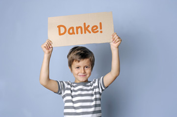 Kind sagt Danke mit einem Schild