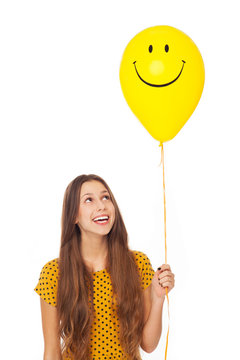 Young Woman Holding Smiley Face Balloon