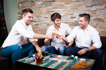 Männer beim Pokerabend stoßen miteinander an