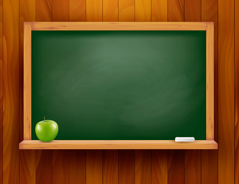 Blackboard with green apple on wood background.