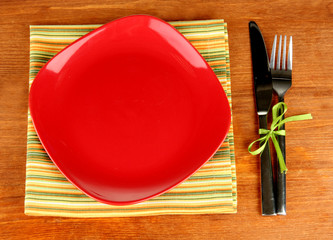 Empty square red plate with fork and knife