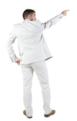 Back view of businessman pointing at wall.
