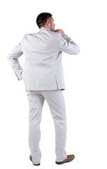 Back view of  thinking young business man in  white suit.