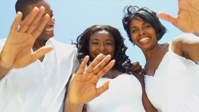 Close up of ethnic happy family skyping together on beach 