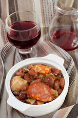 sausages and beans stew with glass of wine
