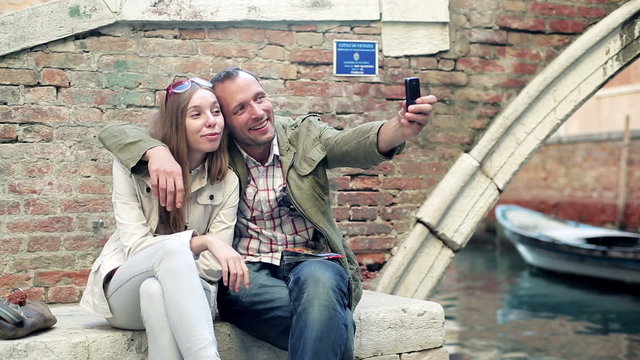 Tourists couple taking a photo with smartphone in Venice 