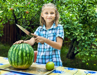Fototapeta premium Young girl cut ripe watermelon