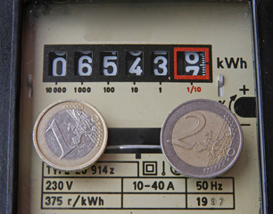 electricity meter with two coins of one and two euros