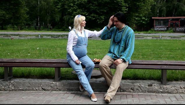 Мужчина и беременная женщина едят пончики
