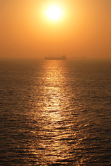 Sunrise over the sea with boats in the distance