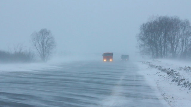 cars on winter road at blizzard