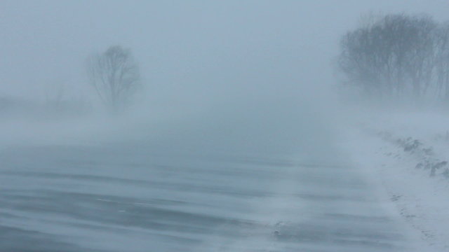 cars on winter road at blizzard