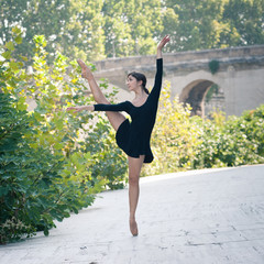 Fototapeta na wymiar Young beautiful ballerina dancing in Tevere riverside in Rome.