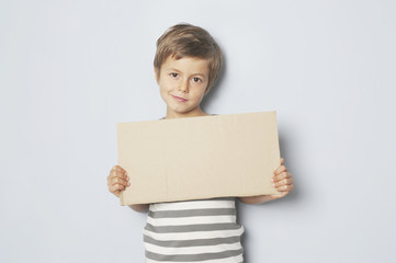 Junge h&auml;lt Pappschild mit Textfreiraum