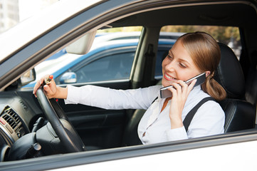 woman sitting in the car and talking on the phone