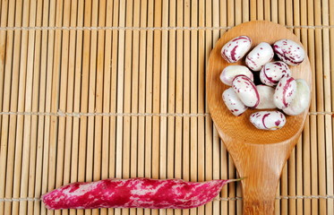 purple beans over a spoon on a bamboo placemat