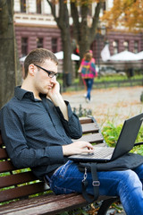 a young man with a laptop outdoors
