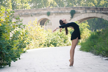 Young beautiful ballerina dancing in Tevere riverside in Rome