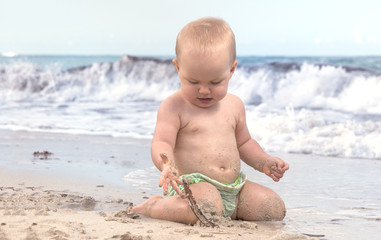 baby girl playing on the beach