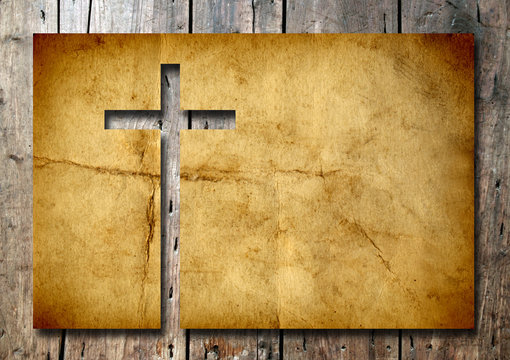 High resolution christian cross cut in an old paper on wood