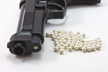 White balls with an black gun (airsoft) isolated on white