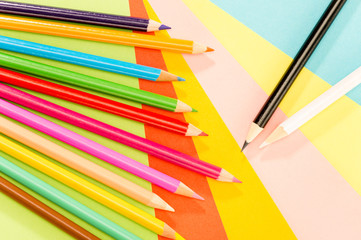 Fototapeta premium Color pencils on colorful papers close-up