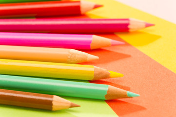 Color pencils on colorful papers close-up