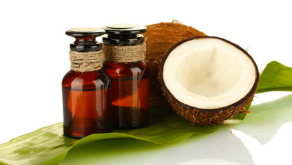 coconut oil in bottles with coconuts on white background