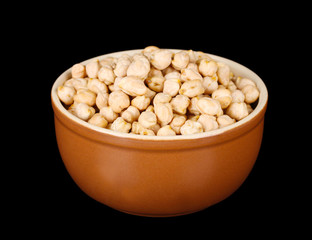 White chickpeas in brown bowl isolated on black