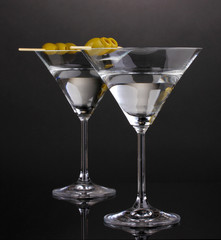 Martini glasses and olives on grey background