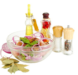 A large piece of pork marinated in bowl with herbs, spices and