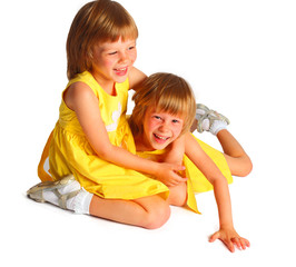 sisters twins in yellow bright dresses have fun in studio