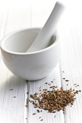 cumin seeds and ceramic mortar