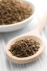 cumin seeds in wooden spoon