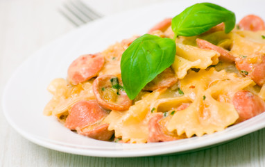 Farfalle pasta with sausage and cream sauce with basil
