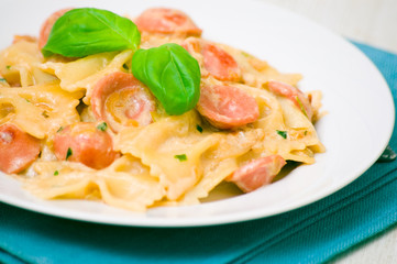 Farfalle pasta with sausage and cream sauce with basil