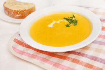 Pumpkin soup in white bowl