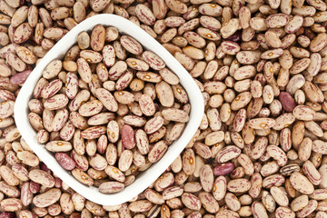 Pinto beans background with a bowl