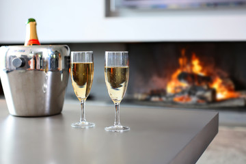 Closeup of champaign glasses set by fireplace
