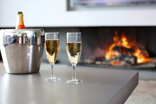 Closeup of champaign glasses set by fireplace