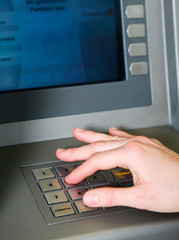 Frau holt Geld am Geldautomat