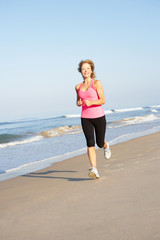 Senior Woman Exercising On Beach