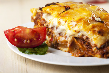 Lasagne auf einem Teller mit Tomate