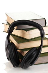 Naklejka premium Headphones on books isolated on white