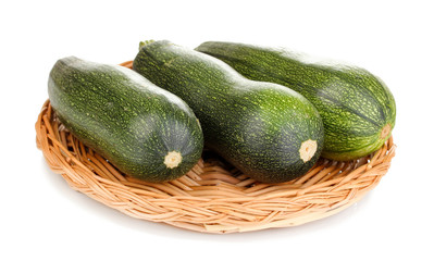 Fresh zucchini on wicker mat isolated on white