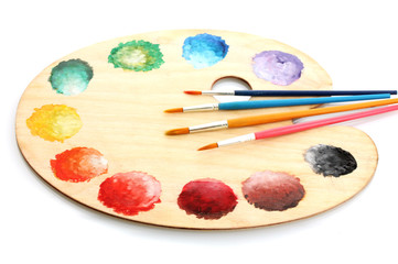 wooden art palette with paint and brushes isolated on white