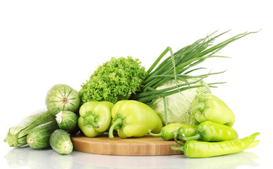 fresh green vegetables on chopping board isolated on white